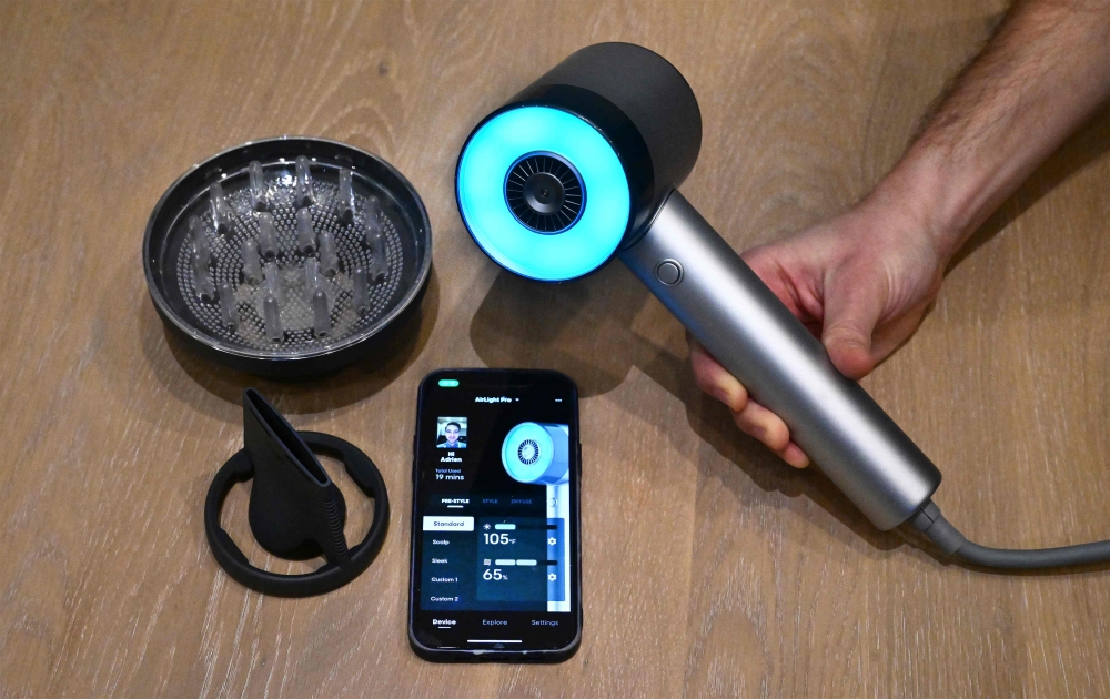 The L'Oreal AirLight Pro hairdryer, powered by patented infrared light technology, is displayed beside attchments for the hairdryer and a cellphone displaying the app at L'Oreal on January 7, 2024 at the 2024 Consumer Electronics Show (CES) in Las Vegas, Nevada. — AFP pic