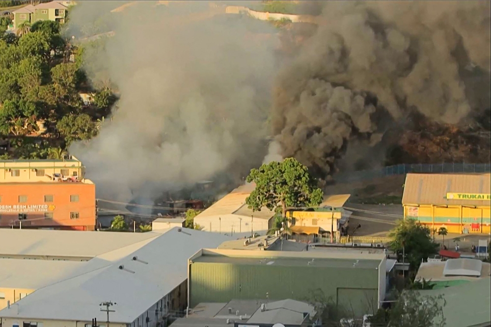 This screen grab from AFPTV video footage taken on January 10, 2024 shows smoke billowing from a building fire amid a state of unrest in Port Moresby. — AFP pic 