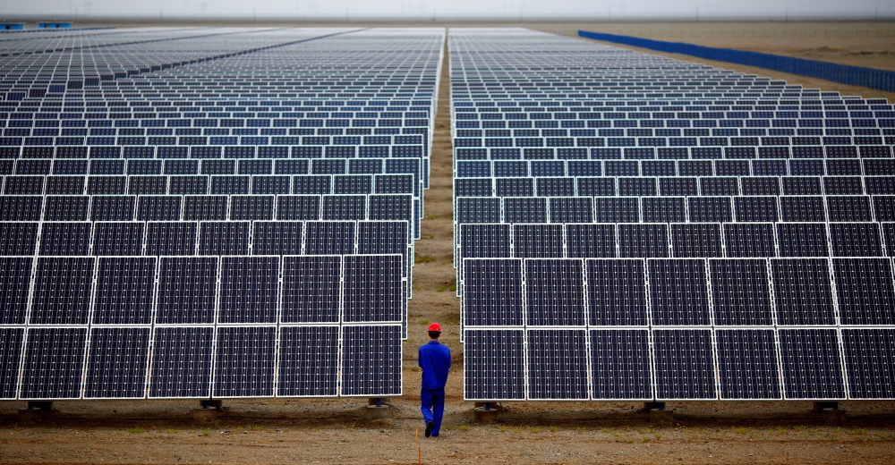 A worker inspects solar panels at a solar Dunhuang, 950km north-west of Lanzhou, Gansu Province September 16, 2013. — Reuters pic  