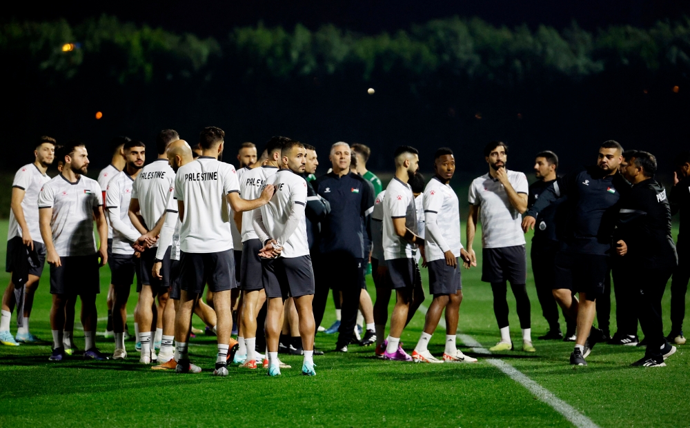 Palestine coach Makram Daboub with his players during training. — Reuters pic