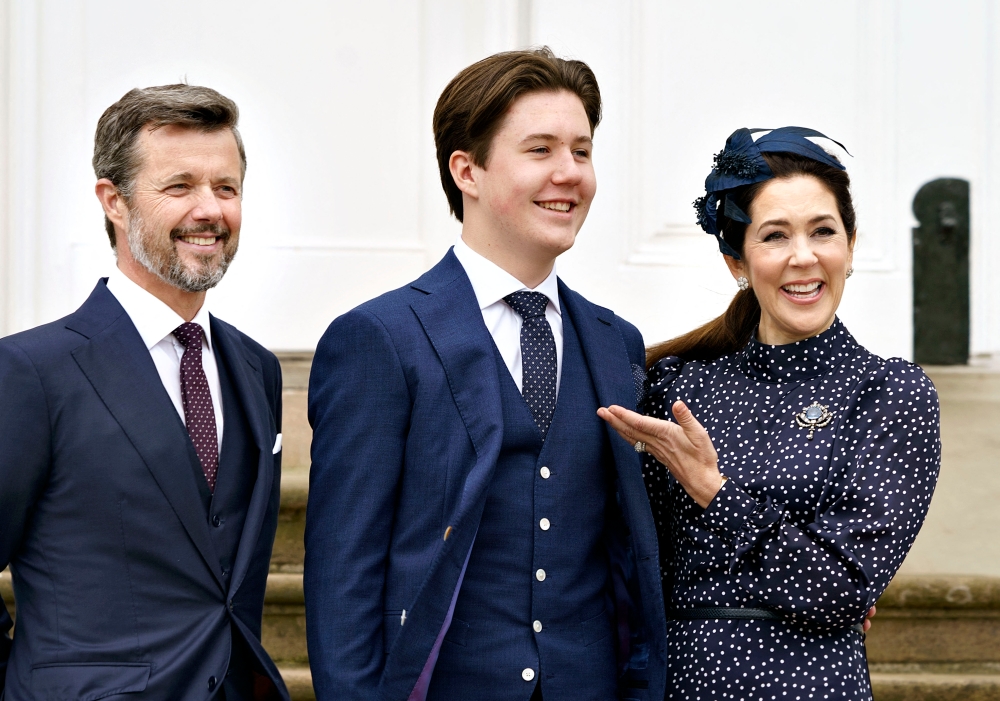 In this file photo stands Prince Christian of Denmark between his parents Crown Prince Frederik and Crown Princess Mary at Fredensborg Castle Church in Fredensborg, Denmark, on May 15, 2021. — AFP pic