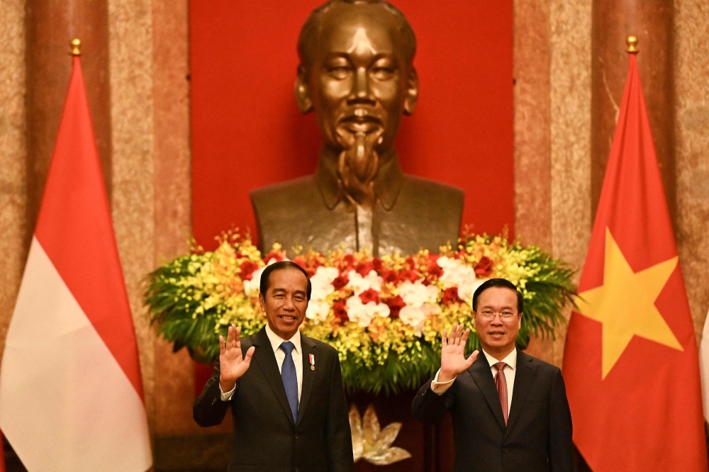 Indonesia's President Joko Widodo and Vietnam's President Vo Van Thuong wave during their meeting at the Presidential Palace in Hanoi on January 12, 2024. — AFP pic