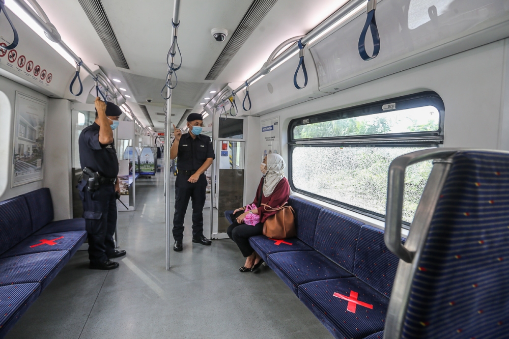 Police personnel conduct a check on KTM Komuter passengers during the movement control order in Shah Alam June 8, 2021. Transport Minister Anthony Loke said KTMB is offering free rides to Klang Valley KTM commuters on January 24 and 25 in conjunction with the Thaipusam festival, which falls on January 25. — Picture by Yusof Mat Isa