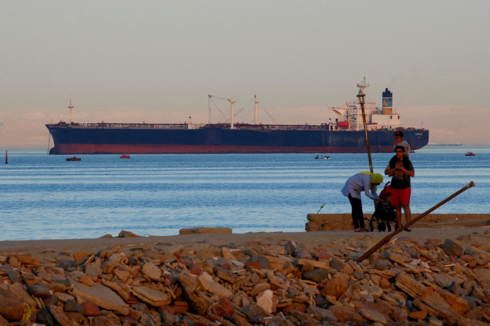 File photo of people walking on the beach as a container ship crosses the Gulf of Suez towards the Red Sea before entering the Suez Canal, in El Ain El Sokhna in Suez, east of Cairo, Egypt April 24, 2017. — Reuters pic