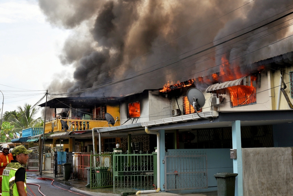 A view of the fire that destroyed low-cost houses at Taman Victoria in Tawau January 12, 2024. A temporary relief centre has been opened at the Tawau Sports Complex’s multi-purpose hall to house 47 Taman Victoria residents who lost their homes after nine double-storey houses along Lorong 4 were destroyed by fire yesterday. — Bernama pic