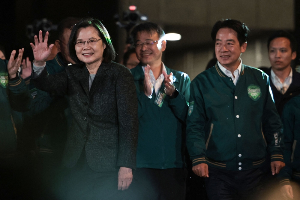Taiwan's President Tsai Ing-wen (left) waves beside President-elect Lai Ching-te (second right) during a rally outside the headquarters of the Democratic Progressive Party (DPP) in Taipei on January 13, 2024, after Lai won the presidential election. — AFP pic
