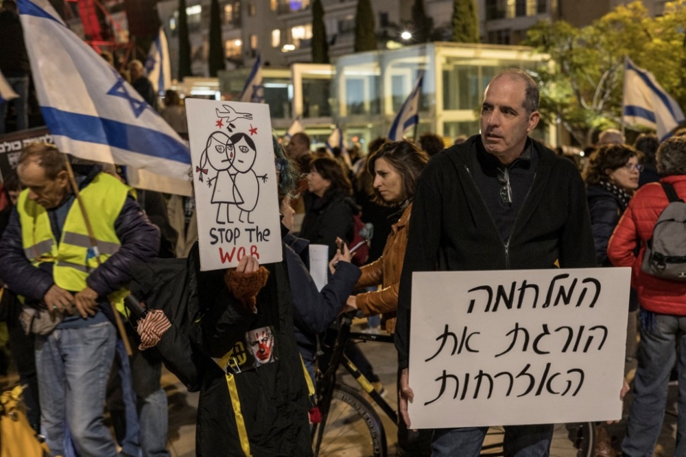 Israeli anti-government protesters hold placards during a demonstration in Tel Aviv, on January 13, 2024, after almost 100 days of war between Israel and the militant Hamas group in Gaza. — AFP pic
