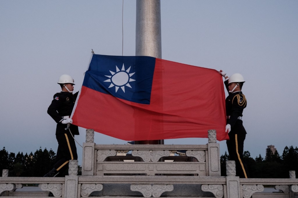 Guards raise Taiwan’s national flag on the Democracy Boulevard at the Chiang Kai-shek Memorial Hall in Taipei on January 14, 2024. — AFP pic