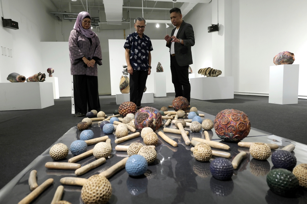 Communications Minister Fahmi Fadzil (centre) listens as ceramic artist Adil Abdul Ghani (right) explains his artwork during the ‘Life: Magnified — The Main Show’ exhibition at Zhan Art in Kuala Lumpur January 13, 2024. — Bernama pic