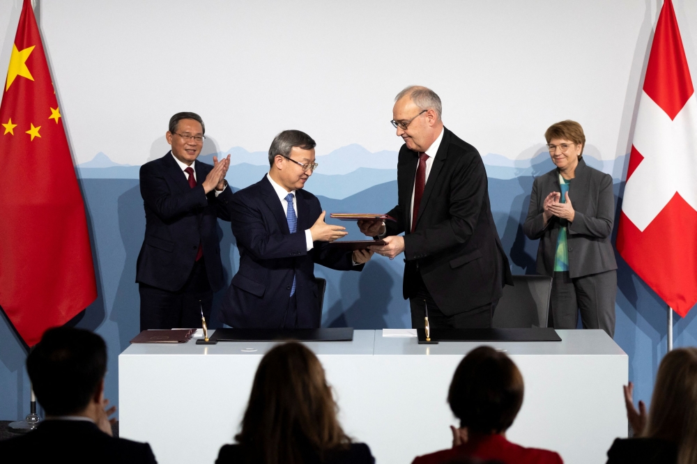 Swiss Federal Minister Guy Parmelin, front right, and Wang Shouwen, Chinese Vice Minister of the Ministry of Commerce, front left, exchange documents after signing a joint statement of the free trade agreement, next to Swiss President Viola Amherd, back right, and Prime Minister of the People's Republic of China, Li Qiang, back left, during an official visit in Kehrsatz near Bern, Switzerland, January 15, 2024. — Reuters pool pic