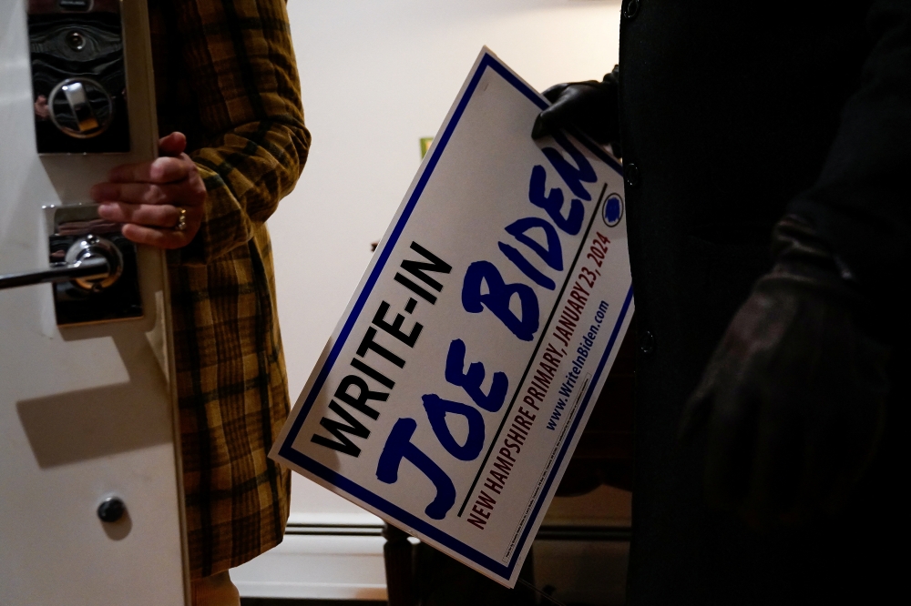 A potential voter takes home a sign after attending a house party supporting the write-in campaign to put U.S. President Joe Biden's name on the New Hampshire Democratic primary ballot, at the home of New Hampshire State Representative Luz Bay in Dover, New Hampshire January 14, 2024. — Reuters pic