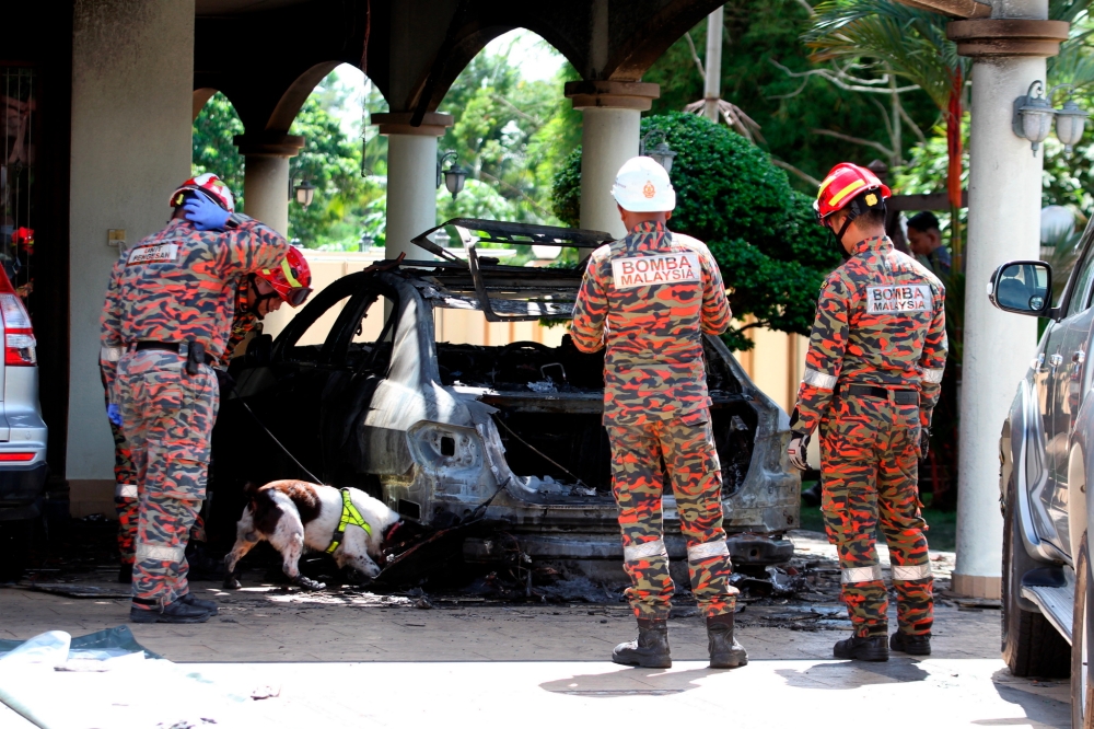 Forensic personnel from the Fire and Rescue Department use a tracker dog at the scene of what was believed to be a Molotov cocktail attack at the home of Beruas MP Datuk Ngeh Koo Ham in Taman Semarak Jaya, Ayer Tawal, Manjung, January 10, 2024. — Bernama pic