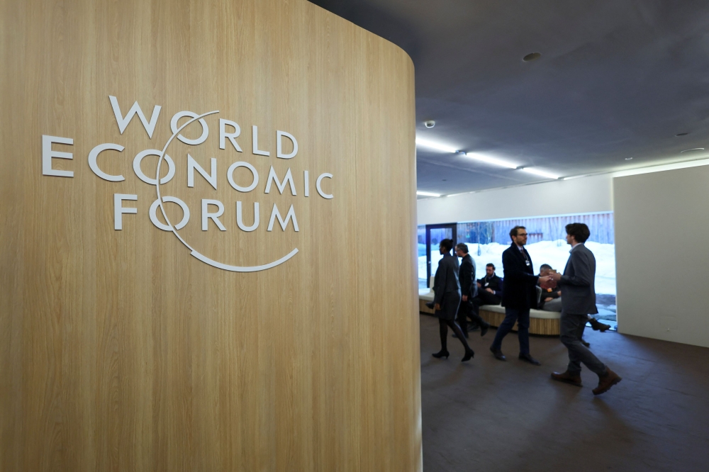 People walk next to the logo of World Economic Forum (WEF) on the first day of the annual meeting in Davos, Switzerland January 15, 2024. — Reuters pic