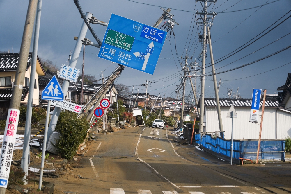 Crooked signs hang over a road damaged in the January 1 earthquake in Nishiaraya, Ishikawa Prefecture, Japan January 8, 2024. ― Reuters pic