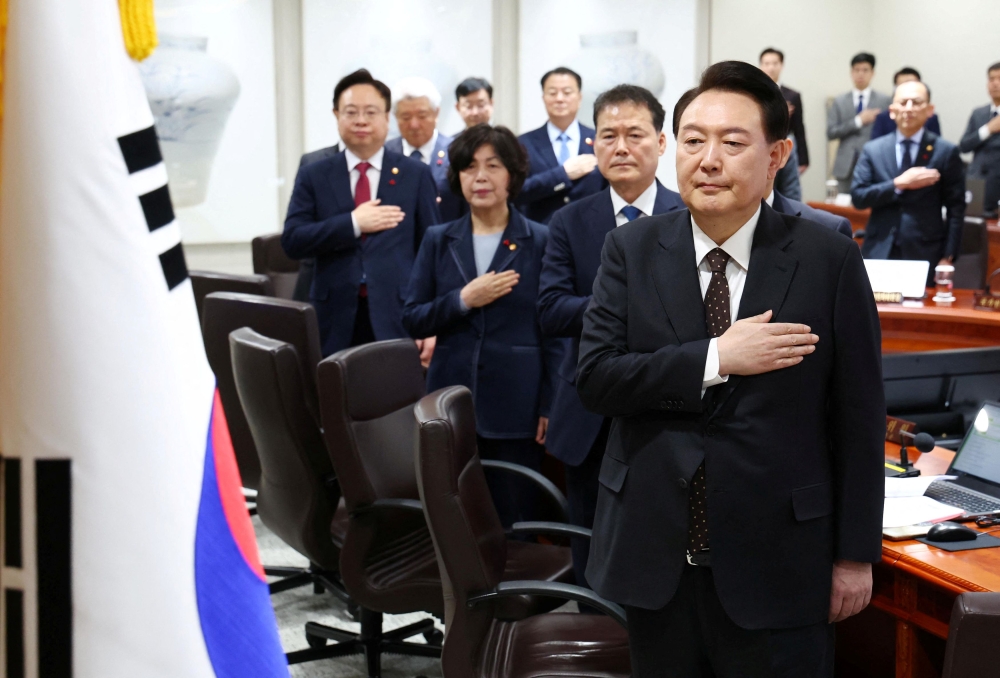 South Korean President Yoon Suk Yeok salutes the national flag during a cabinet meeting at the Presidential Office in Seoul, South Korea, January 16, 2024. — Yonhap pic via Reuters