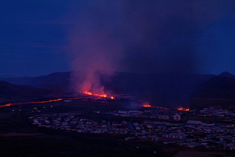 Smoke rises as lava flows from a volcano in Grindavik, Iceland, on January 14, 2024. —  Icelandic Coast Guard handout via Reuters pic