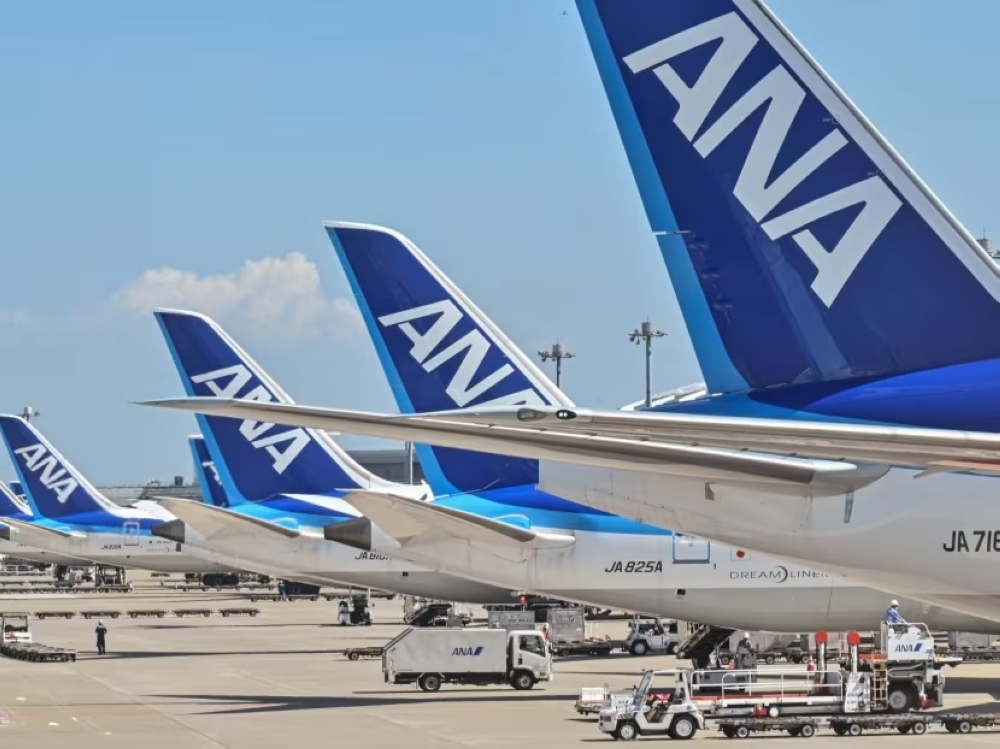 This photo taken on July 23, 2023 shows a worker on the tarmac behind a line of planes for Japanese airline All Nippon Airways (ANA) at Tokyo International Airport at Haneda in Tokyo. — AFP pic 