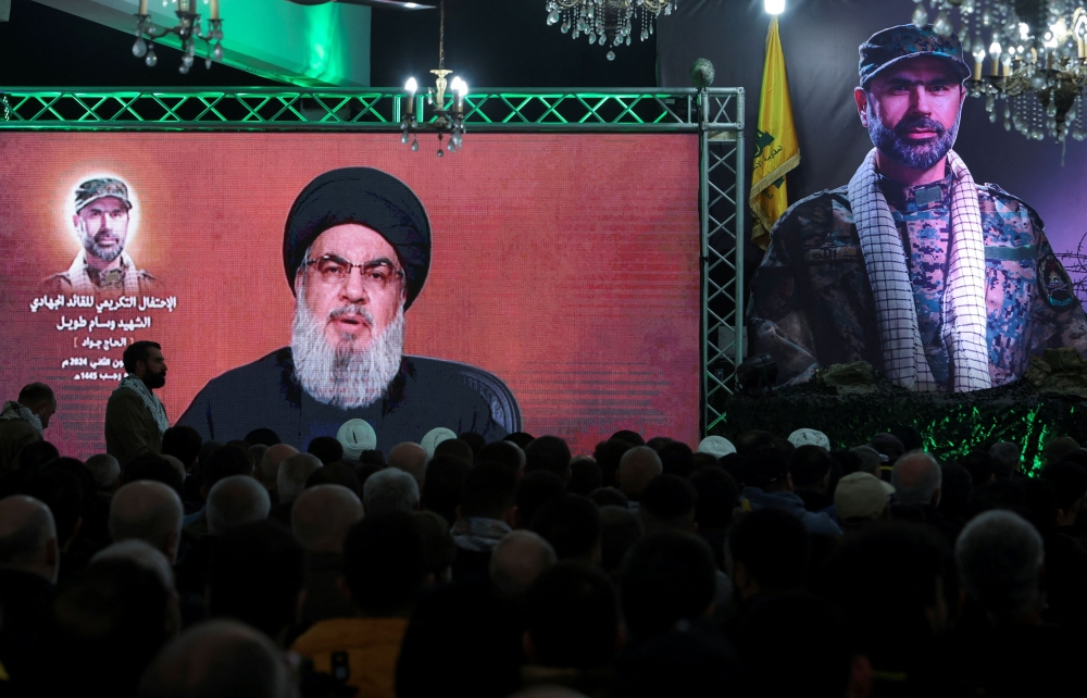 Lebanon's Hezbollah leader Sayyed Hassan Nasrallah appears on a screen as he gives a televised address at a memorial ceremony to mark one week since the killing of Wissam Tawil, a commander of Hezbollah's elite Radwan forces, in Khirbet Silem, southern Lebanon, January 14, 2024. — Reuters pic