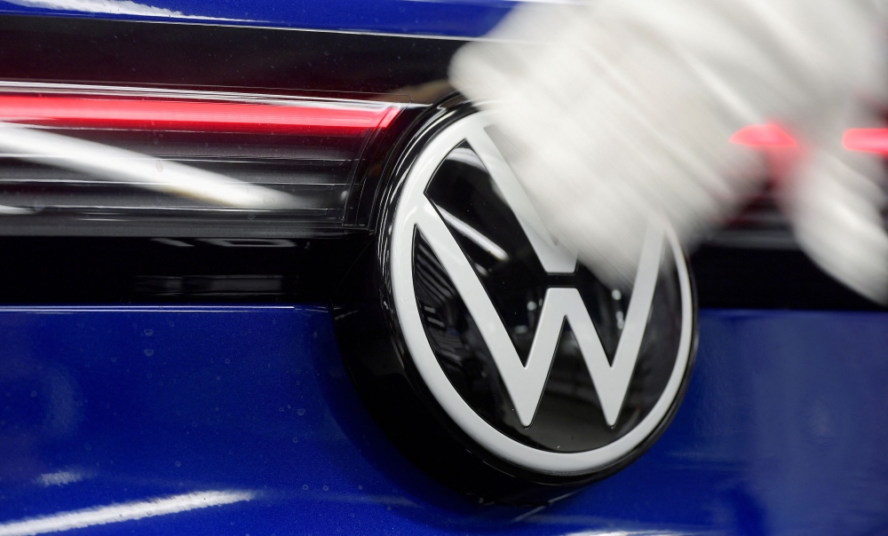  A technician cleans a Volkswagen logo at the production line for electric car models of the Volkswagen Group, in Zwickau April 26, 2022. — Reuters pic  