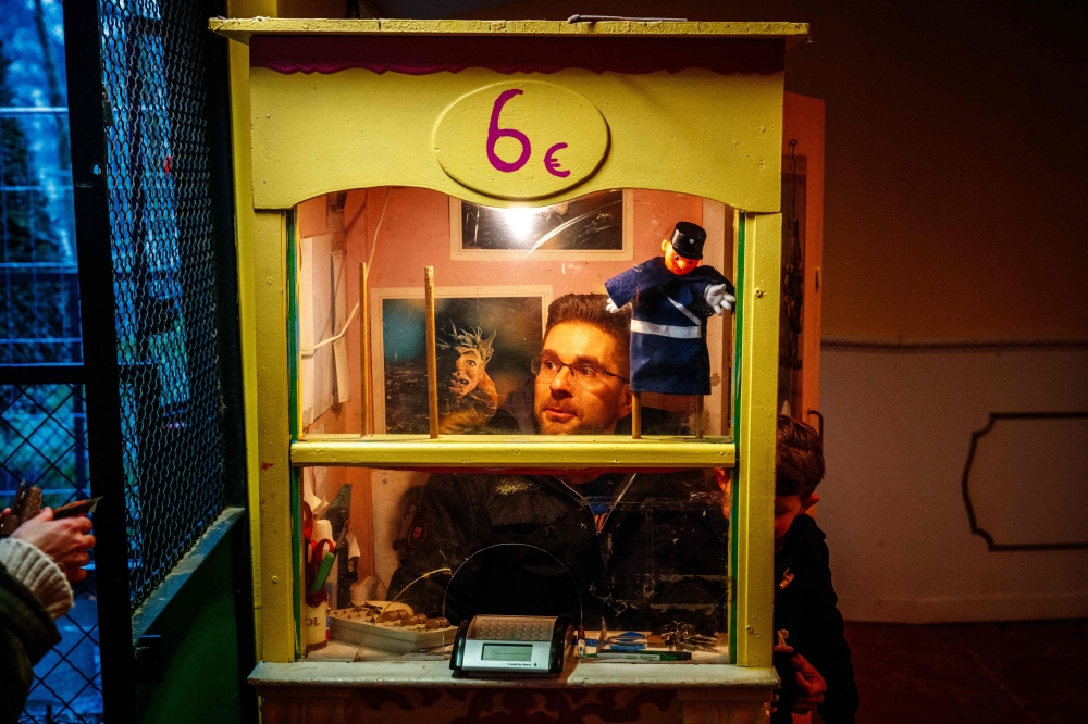 Julien Sommer sells tickets before the start of an adaptation of ‘Beauty and the Beast’ in the small ‘Marionnettes du champ de Mars’ Guignol theatre, near the Eiffel Tower in Paris January 17, 2024. — AFP pic 