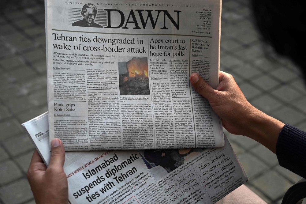 A man reads the frontpage of the Pakistani English-language newspaper Dawn displaying news on Iran's airstrike, in Islamabad January 18, 2024. — AFP pic