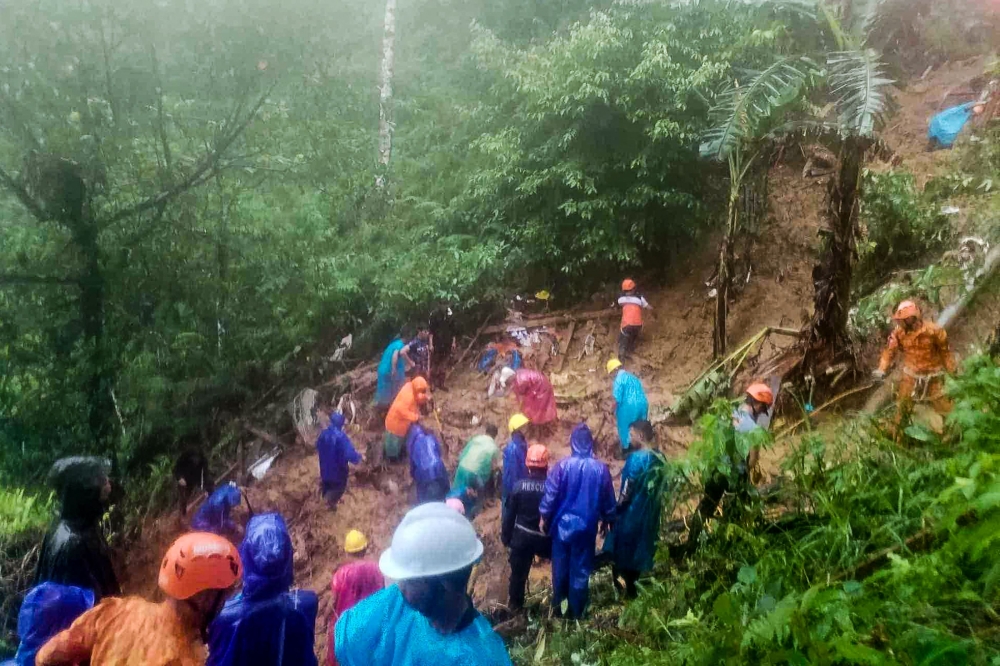 This handout photo taken and released by the Municipality of Monkayo on January 18, 2024 shows rescuers conducting a rescue and retrieval operation, a day after a landslide hit a house in Monkayo, where at least seven people were killed, a disaster official said, with the death toll expected to rise. — Municipality of Monkayo handout pic via AFP