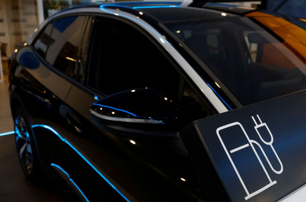  A sign for electric car charger is put near a Volkswagen ID.5 electric car on display at a showroom of a car dealer in Reze November 13, 2023. — Reuters pic  