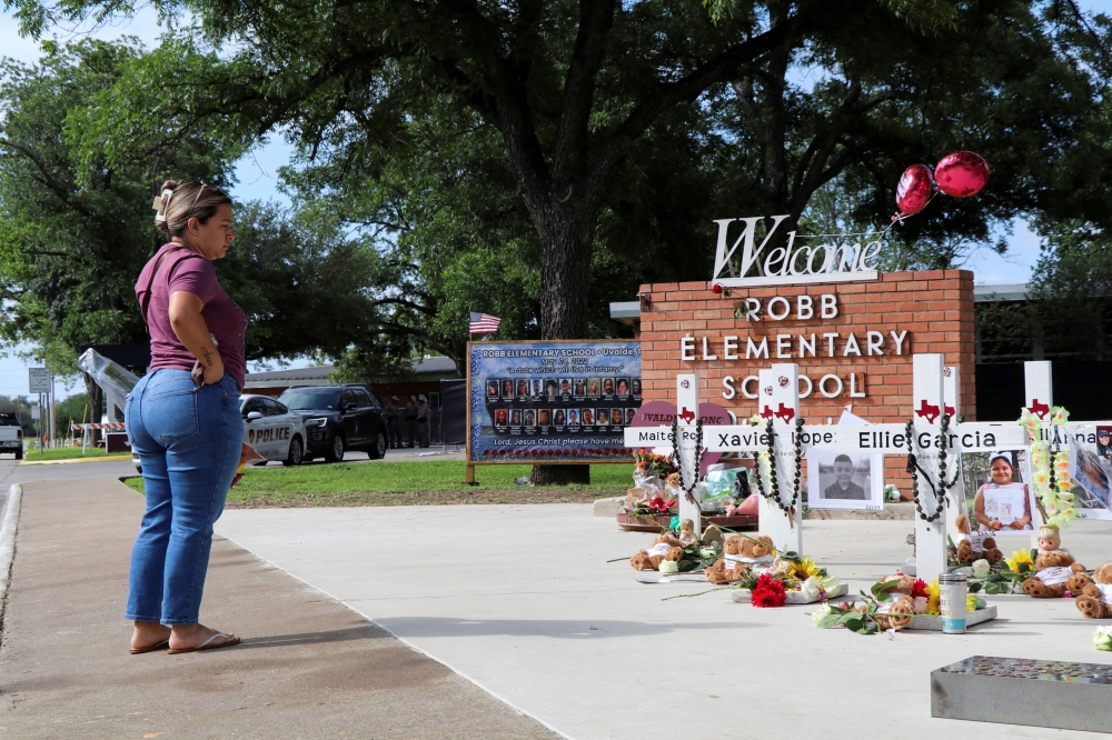 A woman brings flowers to a memorial for the victims of a school shooting at Robb Elementary School, one year after the shooting, in Uvalde, Texas May 24, 2023. ― Reuters file pic