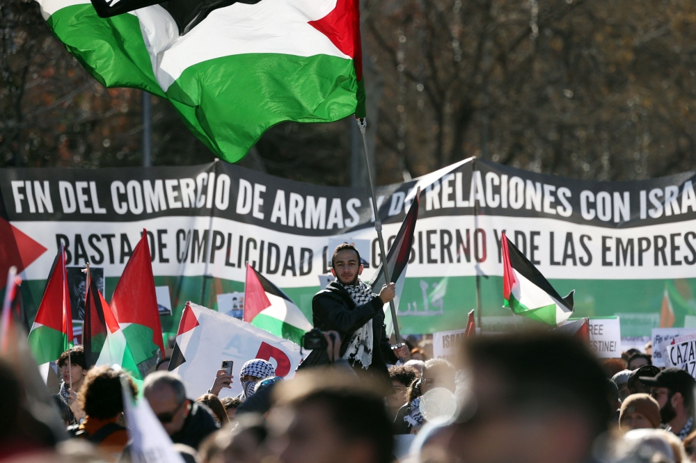 A man waves a Palestinian flag during a rally in support of the people from Gaza, in the Palestinian territories, in Madrid on January 20, 2024. — AFP pic