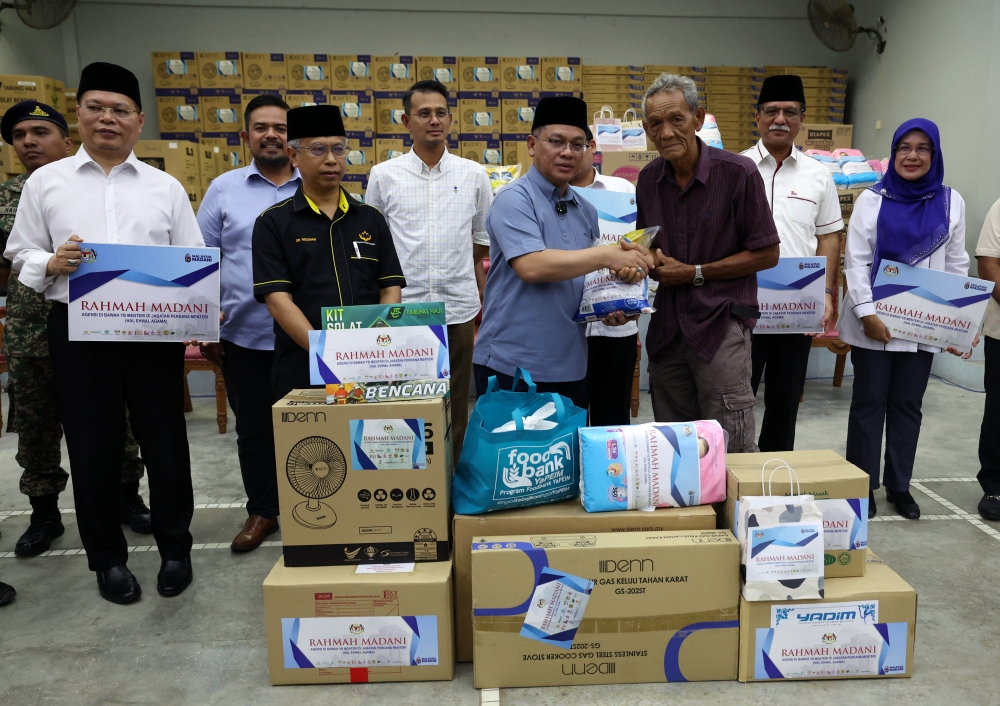 Minister in the Prime Minister’s Department (Religious Affairs) Senator Datuk Mohd Na’im Mokhtar presents aid to 120 heads of households affected by the flood in Kampung Sungai Telor January 21, 2024. — Bernama pic
