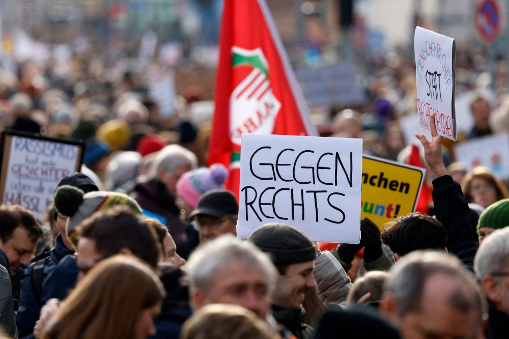 A participant holds up a placard with the lettering 'Against the right wing' during a demonstration against racism and far-right politics in Munich, southern Germany on January 21, 2024. — AFP pic