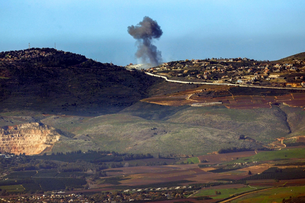 This picture taken from a position in northern Israel along the border with Lebanon on January 20, 2024 shows smoke billowing over the Lebanese village of Odaisseh during Israeli bombardment, amid ongoing cross-border tensions as fighting continues between Israel and Hamas militants in Gaza. — AFP pic