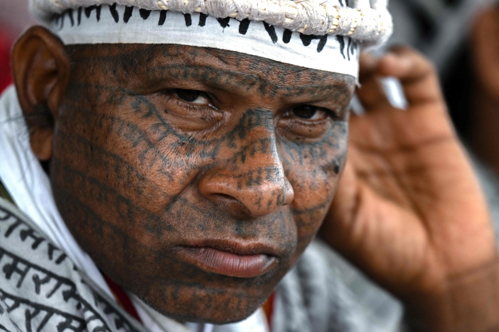 In this photograph taken on January 20, 2024, a member of the Ramnami religious movement with tattoos of Hindu god Ram's name on his body looks on during Ramnami Samaj Hindu festival (Bhajan mela) near the Mahanadi river in Jaijaipur of India's Chhattisgarh state. — AFP pic