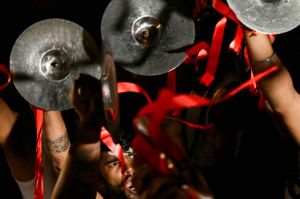 Devotees perform by playing musical instruments in Ayodhya on January 21, 2024, on the eve of the consecration ceremony of a temple to Hindu deity Ram. — AFP pic