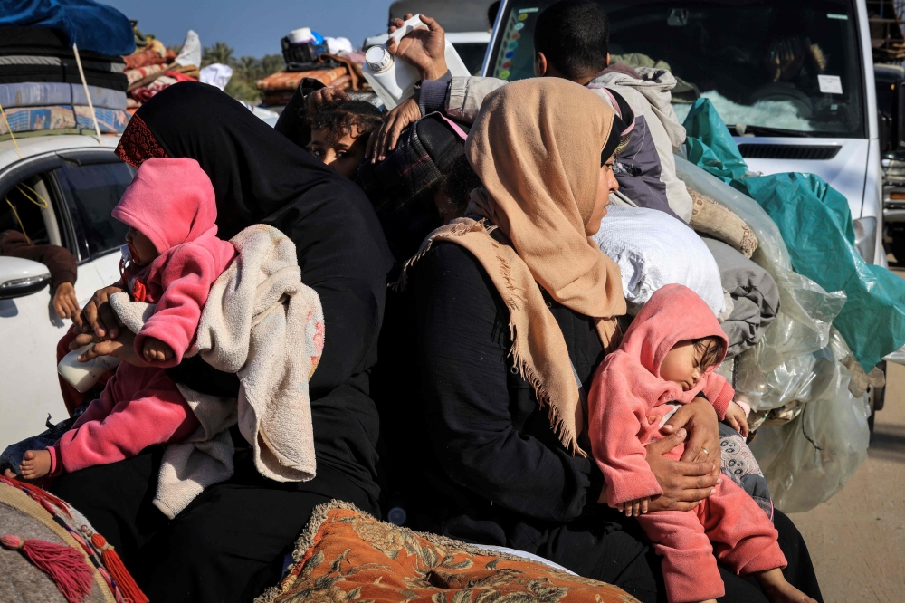 This photograph taken on January 22, 2024 on the southern outskirts of Khan Yunis, in the southern Gaza Strip, shows Palestinian families fleeing the city on the coastal road leading to Rafah, amid ongoing battles between Israel and the Palestinian group Hamas. — AFP pic