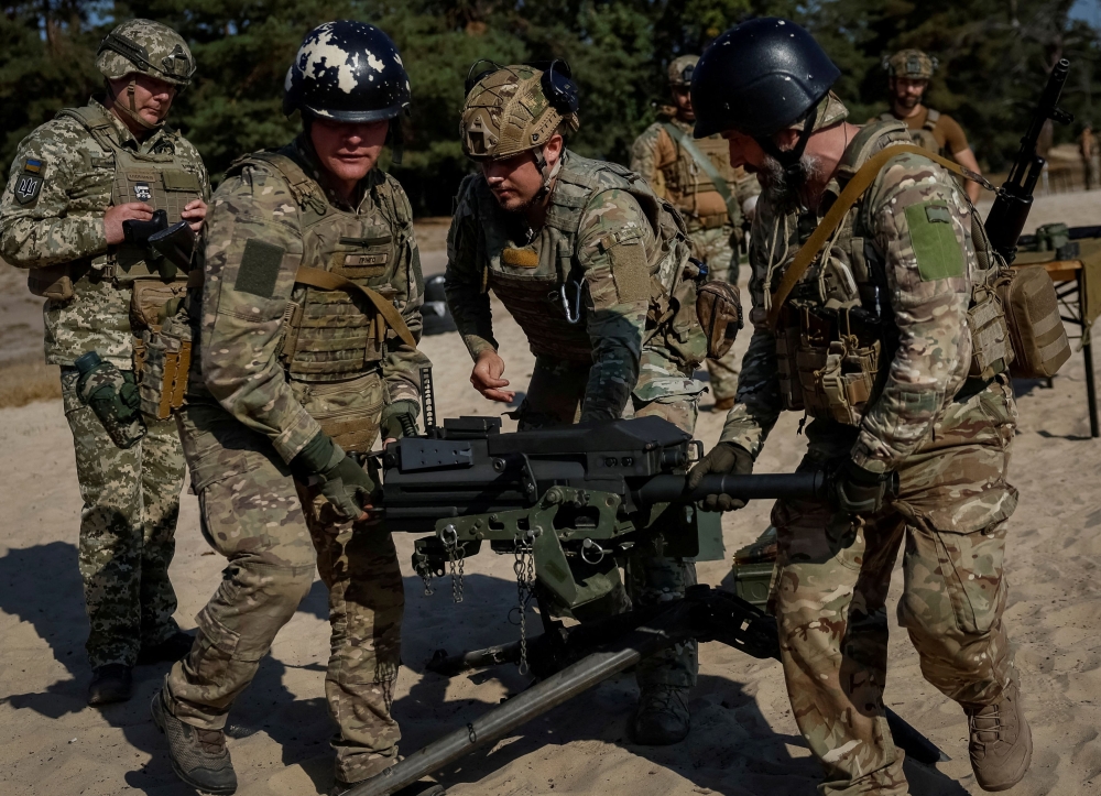 Ukrainian servicemen carry an American Mk19 automatic grenade launcher during a military exercise, amid Russia's attack on Ukraine, in Kyiv region. — Reuters file pic