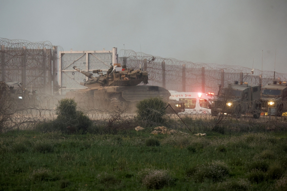 A tank manoeuvres along the Israel-Gaza border fence, amid the ongoing conflict between Israel and the Palestinian Islamist group Hamas, in Israel January 22, 2024. — Reuters pic