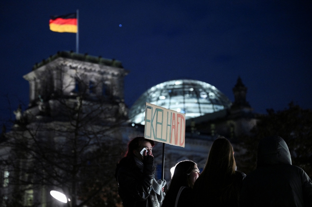 A person holds a sign reading: ‘Disgusting AfD’, near the Reichstag building, seat of the lower house of parliament Bundestag, on the day of a demonstration of a broad alliance under the slogan #TogetherAgainstRight to protest against the Alternative for Germany party (AfD), right-wing extremism and for the protection of democracy, in Berlin January 21, 2024. — Reuters pic