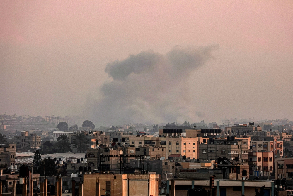 A picture taken from Rafah on January 23, 2024 shows smoke billowing over Khan Yunis in the southern Gaza Strip during Israeli bombardment, amid continuing battles between Israel and the Palestinian militant group Hamas. — AFP pic