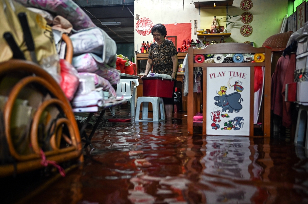 Resident, Lee Keng Ge, 71, salvages some items after her house was flooded following heavy rain since last night at Lorong Gemia, Kuala Terengganu, January 23, 2024. — Bernama pic 