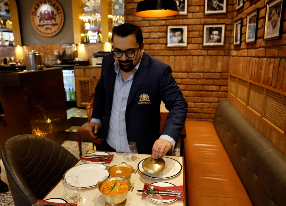 Amit Bagga, CEO of Daryaganj restaurant, shows a freshly prepared butter chicken dish and the lentil dish Dal Makhani inside Daryaganj restaurant at a mall, in Noida January 23, 2024. — Reuters pic  