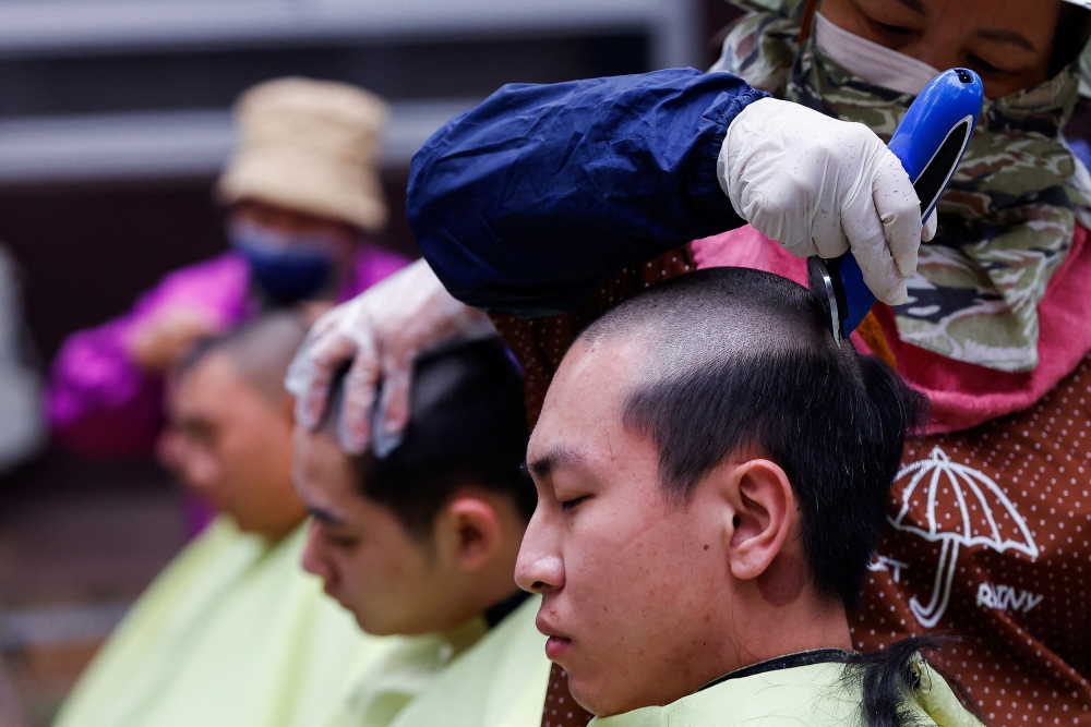 At a recruitment centre in central Taiwan’s Taichung, a group of young men gathered in the morning cold to be inducted, as dogs checked their bags for drugs and barbers shaved their heads before changing into army fatigues. — Reuters pic