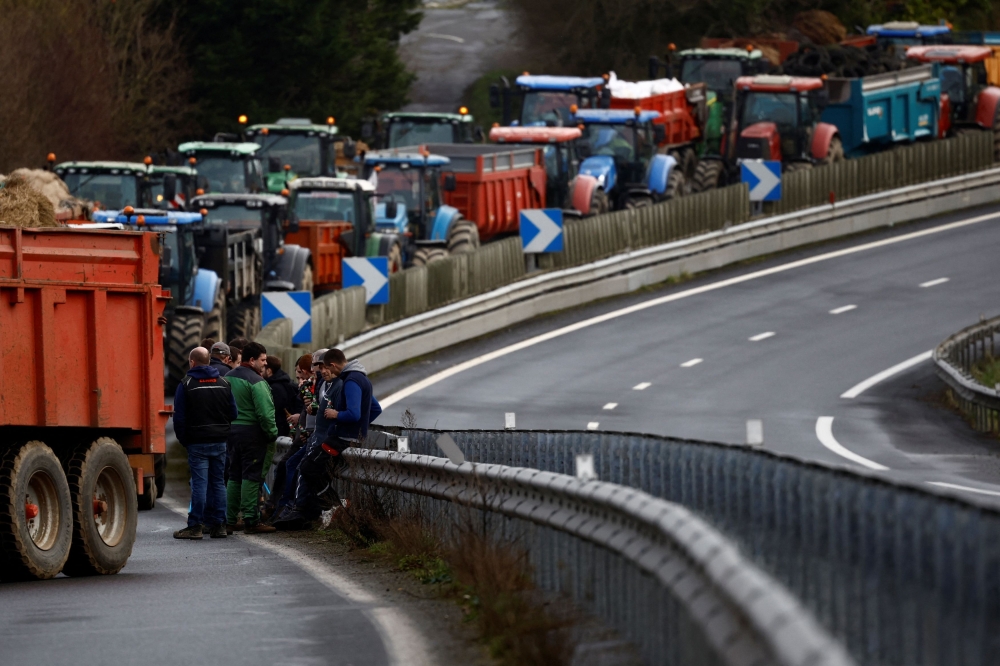 French farmers block the N12 road with their tractors to protest over price pressures, taxes and green regulation. — Reuters pic