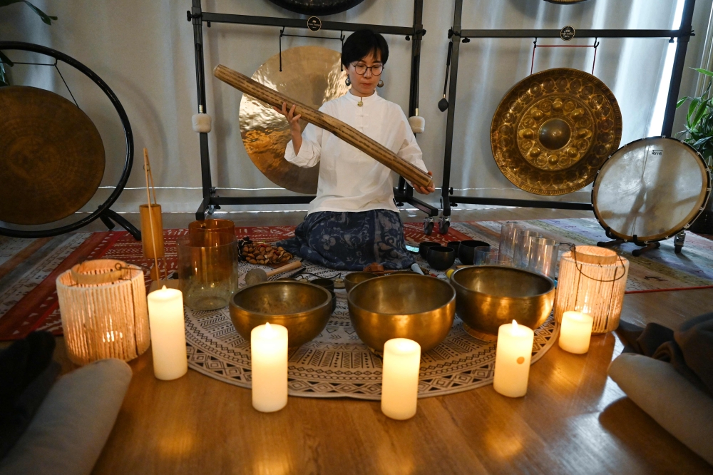 This photo taken on December 8, 2023 shows Li Yan makes sounds with a rain stick during a one-hour sound healing session at theYiyan sound healing studio in Beijing. — AFP pic