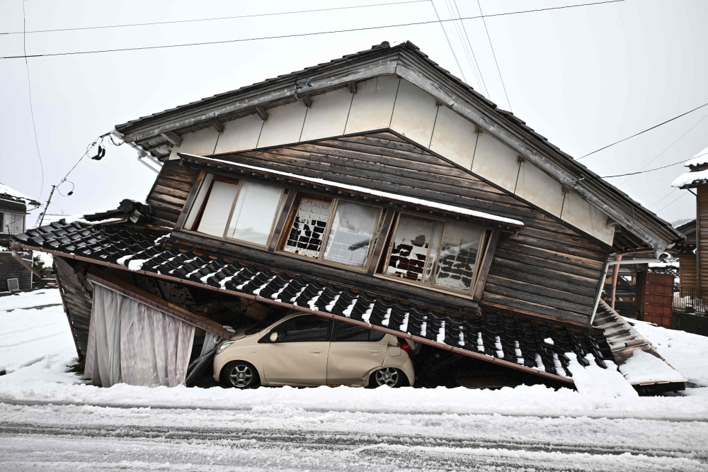 A damaged car lies underneath a collapsed building at Shika town in Hakui District, Ishikawa Prefecture after a major 7.5 magnitude earthquake on New Year’s Day. — AFP pic