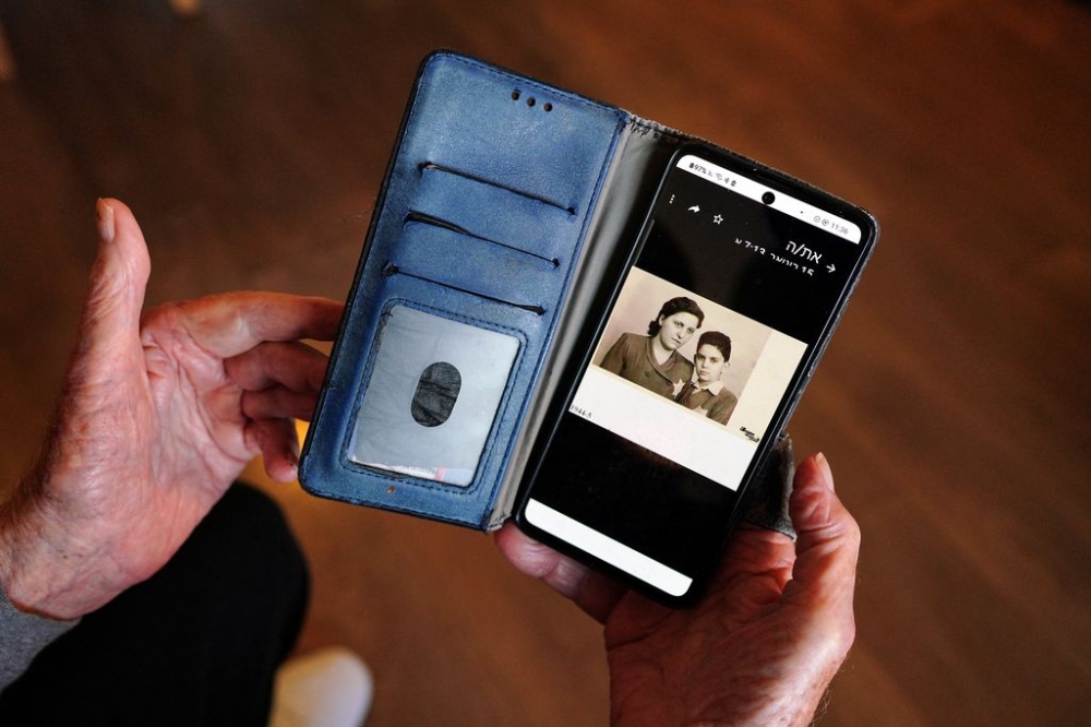 Haim Raanan, 88, a Holocaust survivor who also survived the deadly October 7 Hamas attack on Kibbutz Beeri, shows a picture of himself as a child with his mother, Erin, wearing Stars of David, at his temporary accommodation in Tel Aviv, Israel January 21, 2024. — Reuters pic