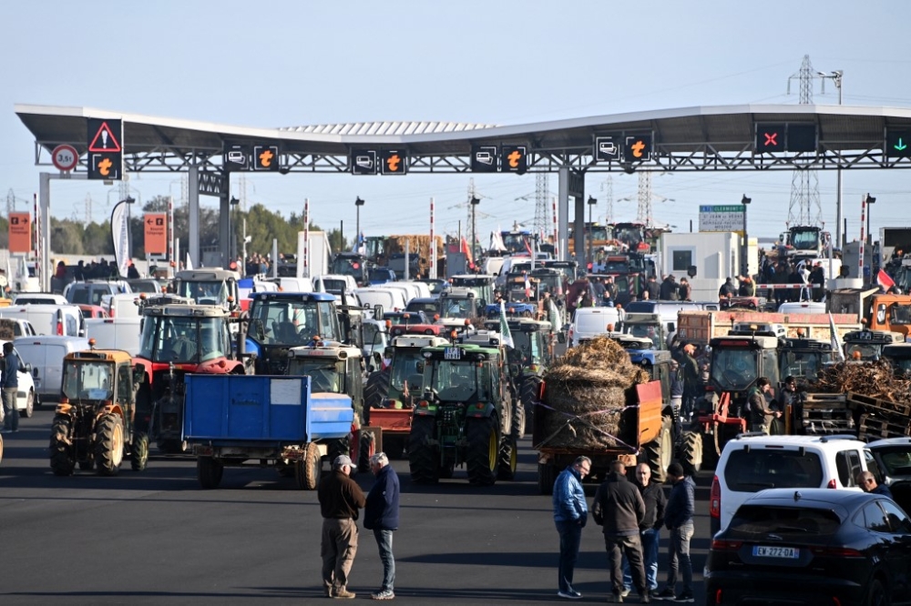 French farmers block the toll of the A9 highway during a demonstration called by French farmer unions to protest against a number of issues affecting their sector, including taxation and falling incomes, in Saint-Jean-de-Vedas, near Montpellier, on January 26, 2024. — AFP pic