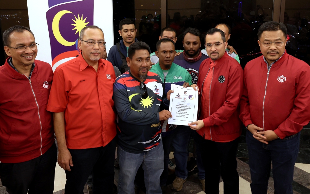 Umno secretary-general Datuk Asyraf Wajdi Dusuki receives a memorandum from Grab Food Malaysia’s delivery partners’ association deputy president Abdul Hakim Abdul Rani at the World Trade Centre in Kuala Lumpur, January 26, 2024. — Bernama pic 