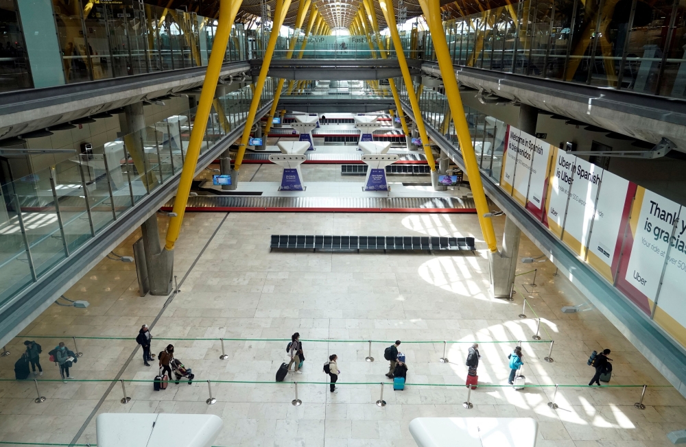 Passengers queue upon arriving at the Adolfo Suarez Barajas Airport in Madrid May 15, 2020. — Reuters pic