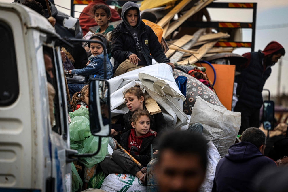 Palestinians carry some belongings as they flee Khan Yunis in the southern Gaza Strip January 26, 2024, amid ongoing battles between Israel and the Palestinian group Hamas. — AFP pic